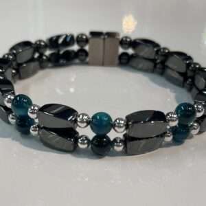 Elegant black and teal beaded bracelet on white surface