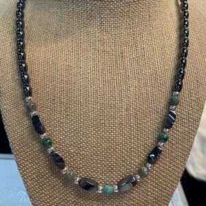 Elegant necklace with black and green stones displayed